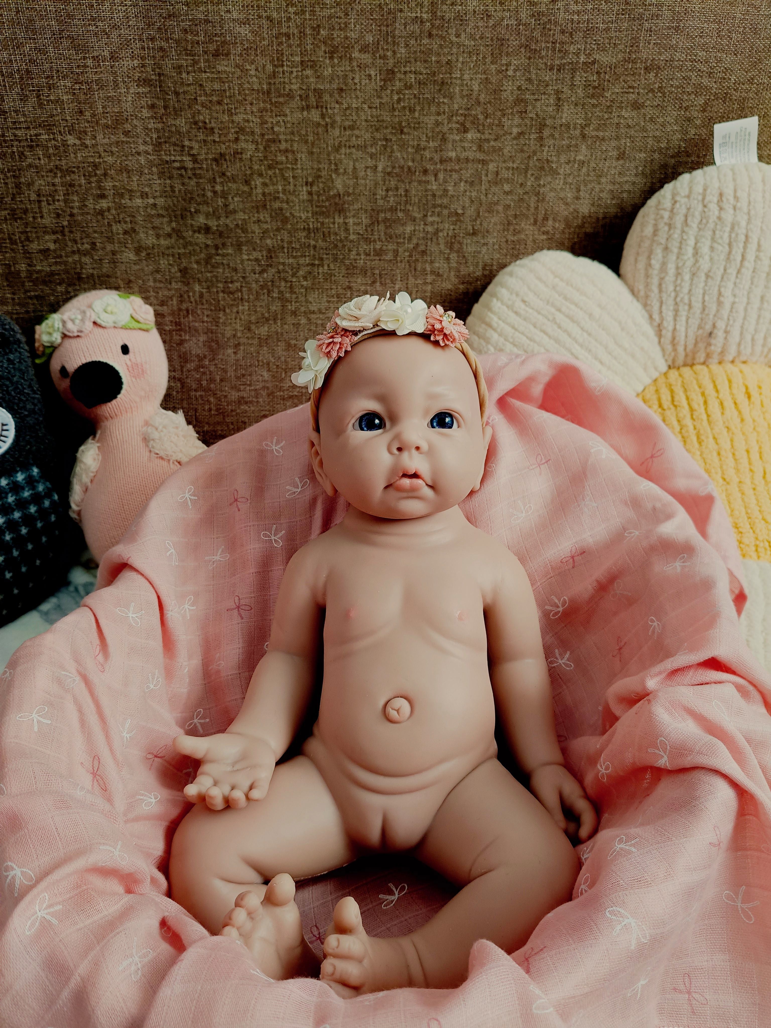 muñeco sobre manta rosa y peluches