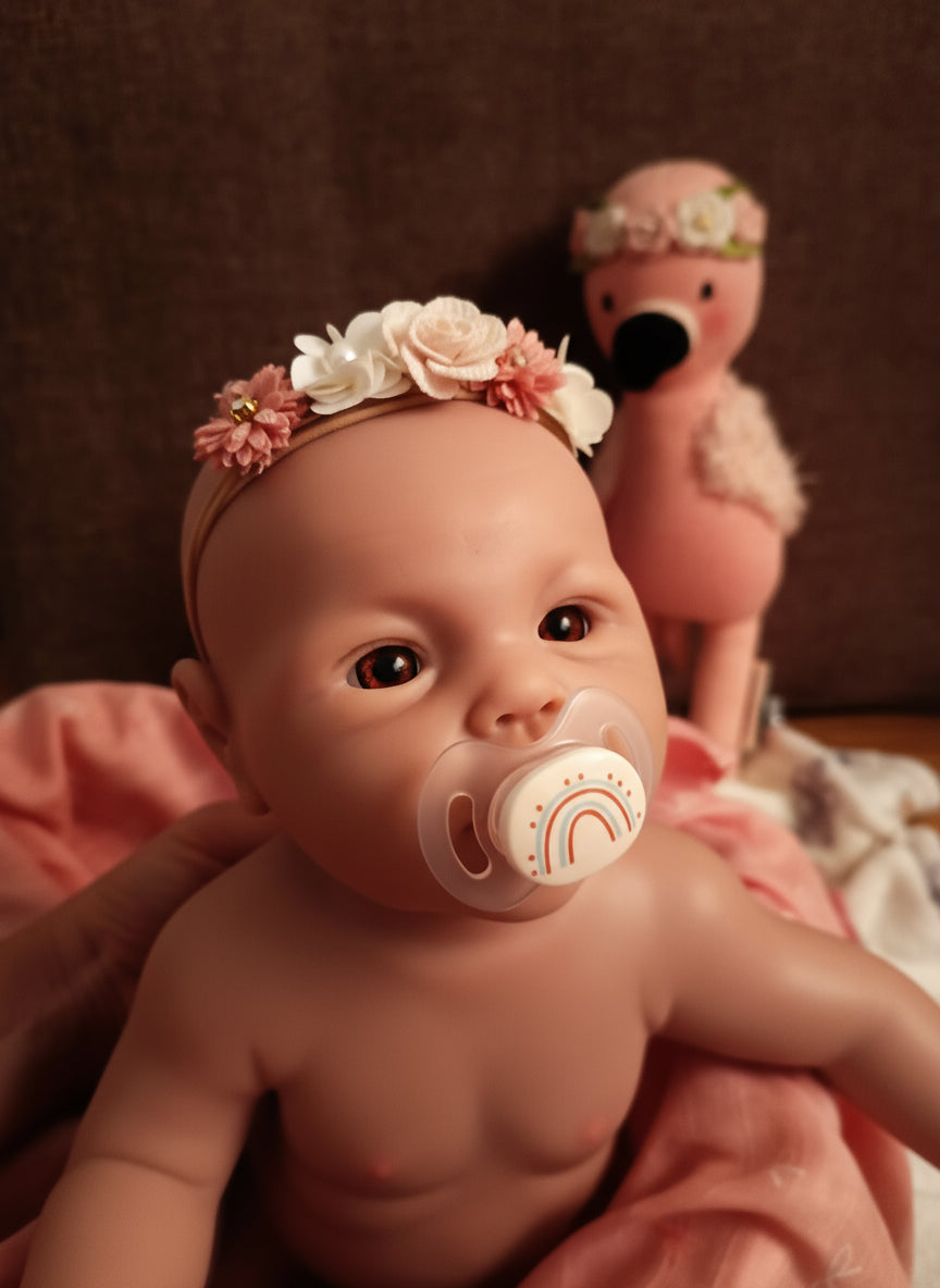 muñeco con peluche rosa y manta rosa