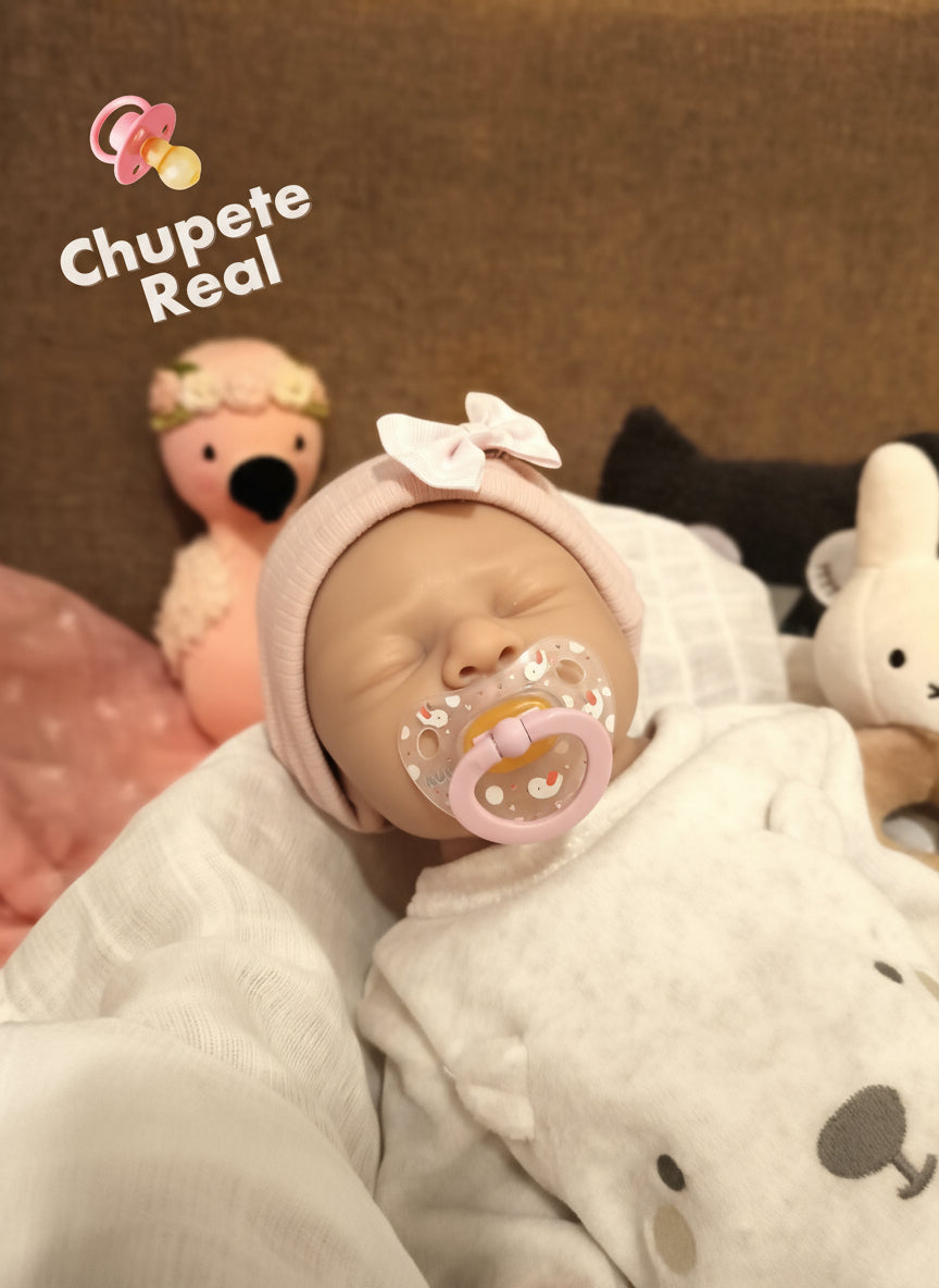 muñeco con chupete y ropa blanca