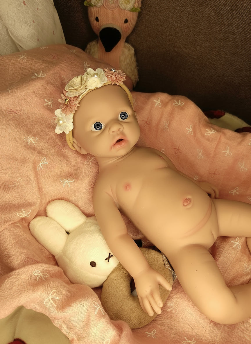 muñeca sobre manta rosa